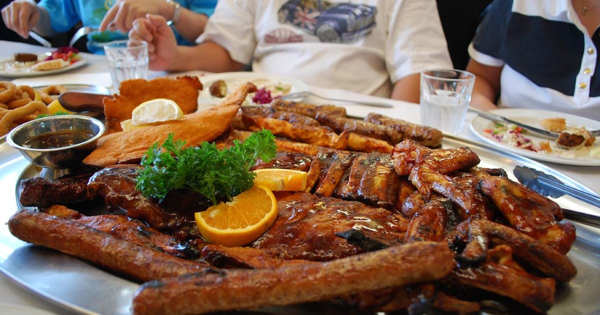 Outdoor cultural festival tables with food and community crowds