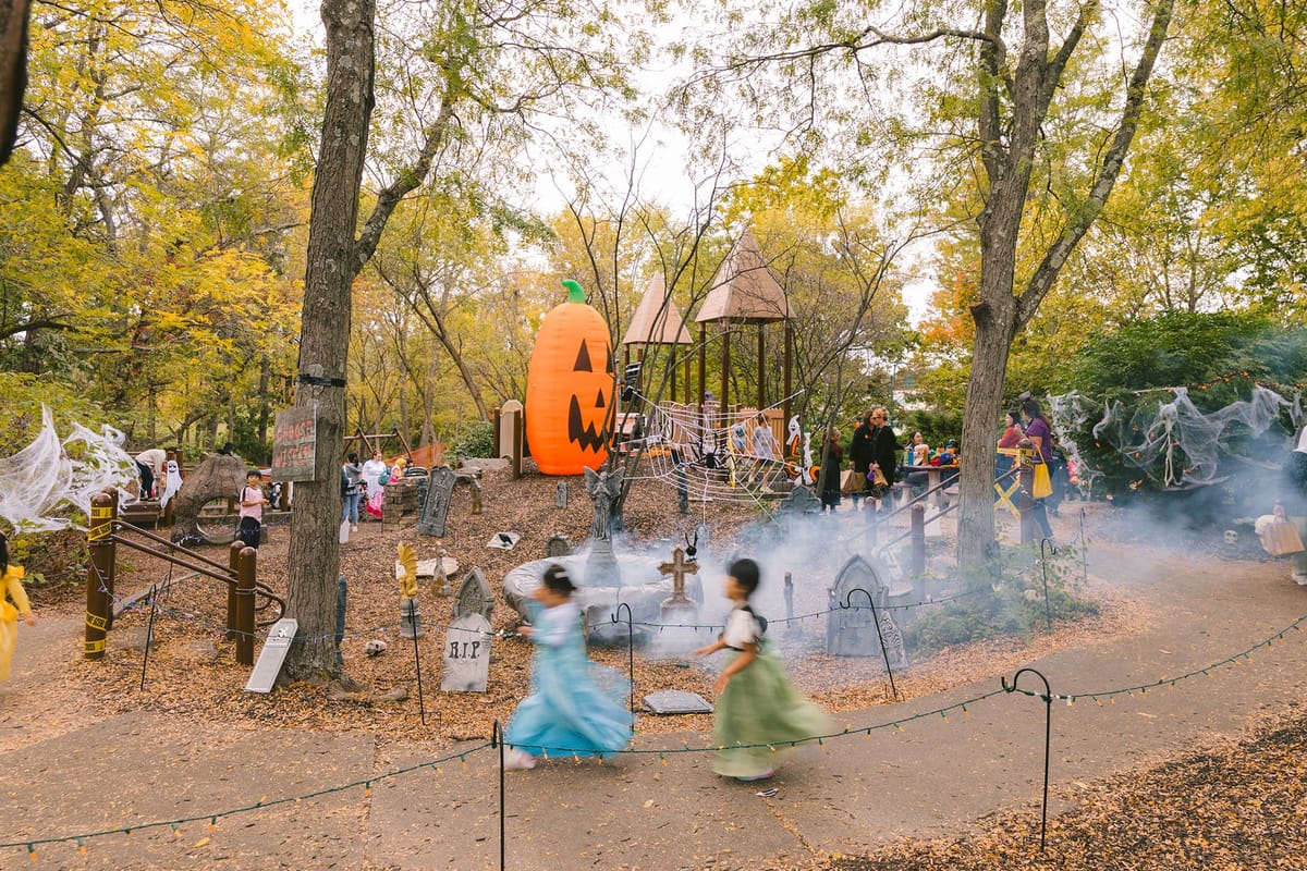 Kids explore a foggy Halloween playground with a giant inflatable pumpkin