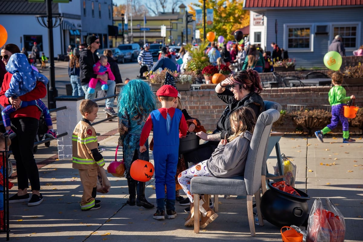 Kids in costumes trick-or-treating at a daytime downtown haunt