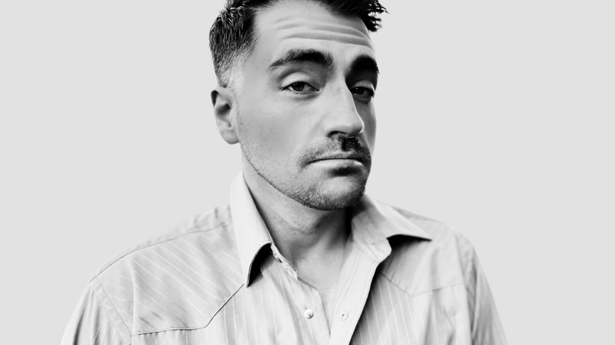 Comedian Trae Crowder black-and-white promotional headshot