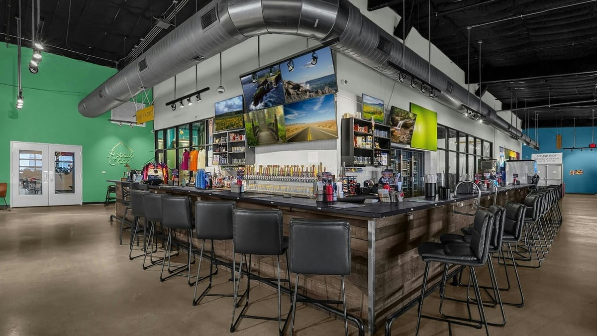 Outerbelt Brewing Carroll taproom bar with stools, beer taps, and TVs under industrial ceiling