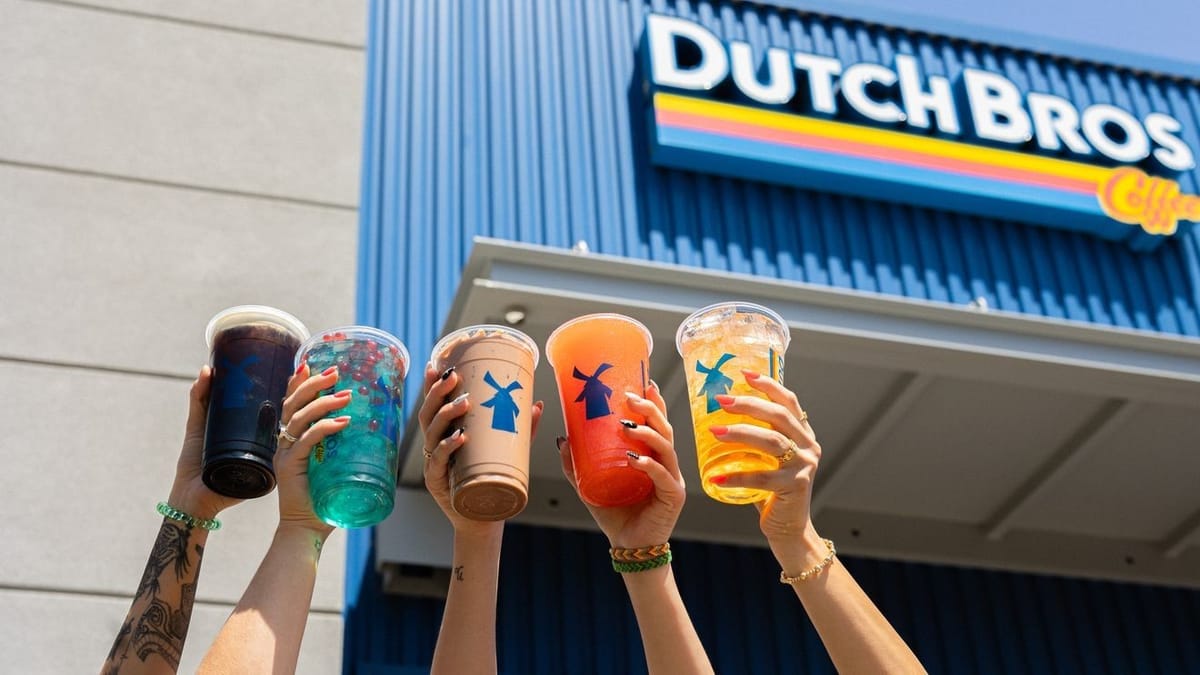 Dutch Bros Coffee drinks held up in front of a Dutch Bros storefront planned for Columbus East Broad