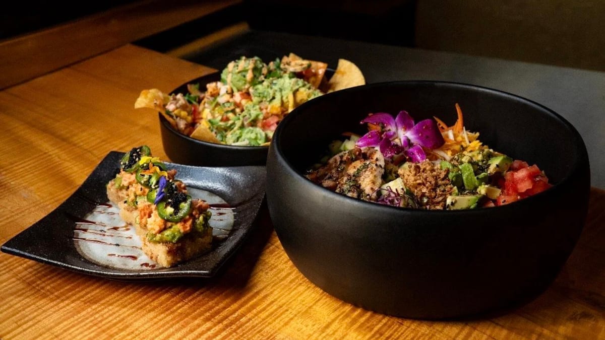 Asian-inspired bowls and crispy rice plates on a wood table at SAGE Downtown