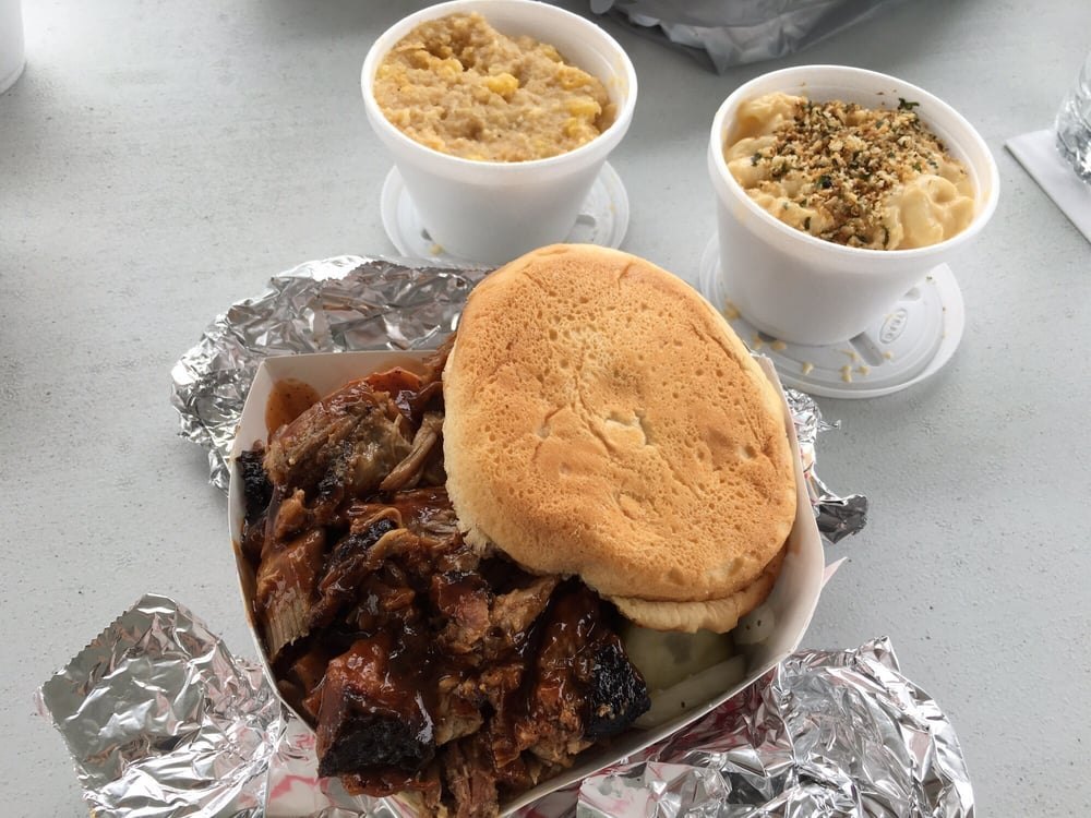 Sauced pulled pork sandwich with mac and corn
