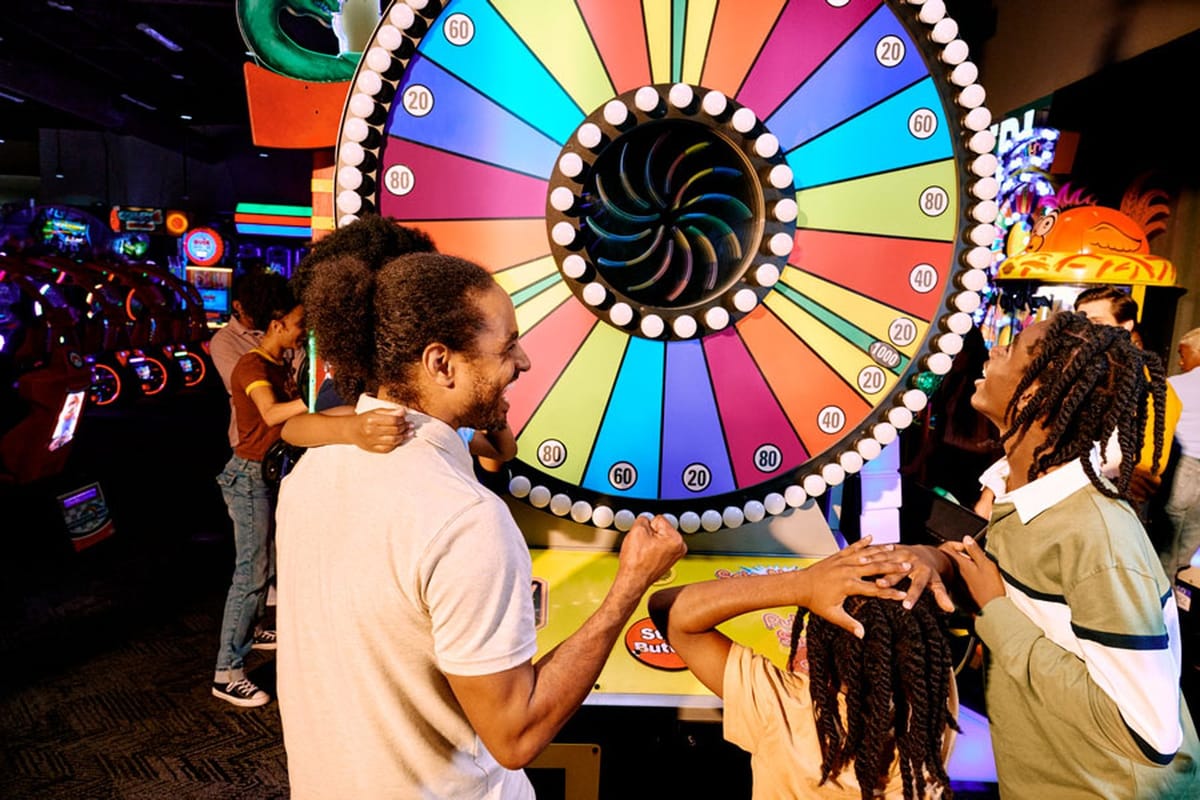 Family at a prize wheel on the Dave & Buster’s arcade midway