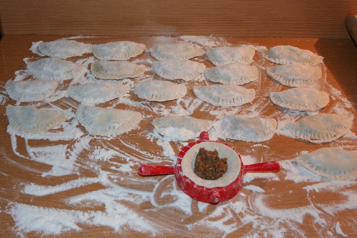 Pan-seared pierogies with sour cream representing Gresso's Famous Pierogies