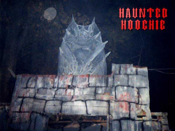 Haunted Hoochie stone castle facade with a pale gargoyle creature perched above the entrance at night