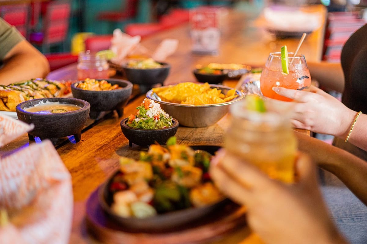 Local Cantina communal table with chips, salsa, and cocktails