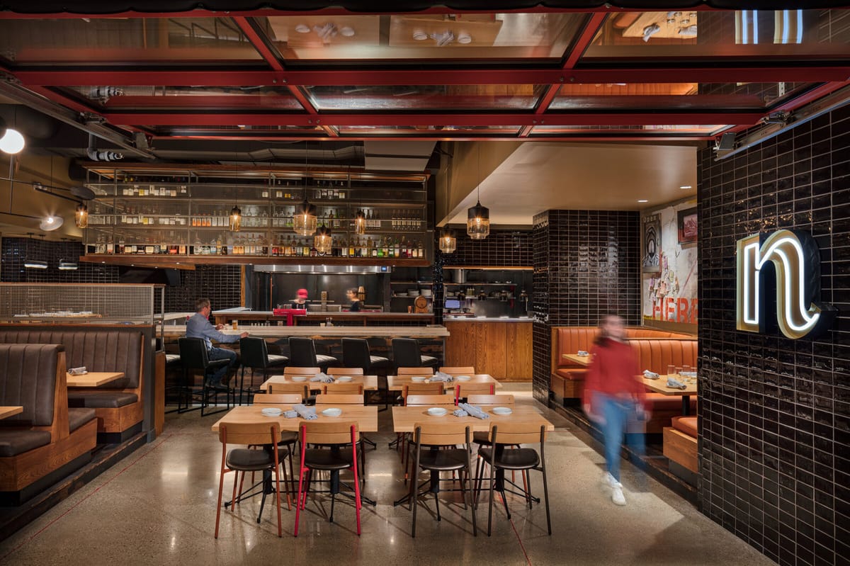 Dining room and glowing Nomad logo inside the Polaris restaurant