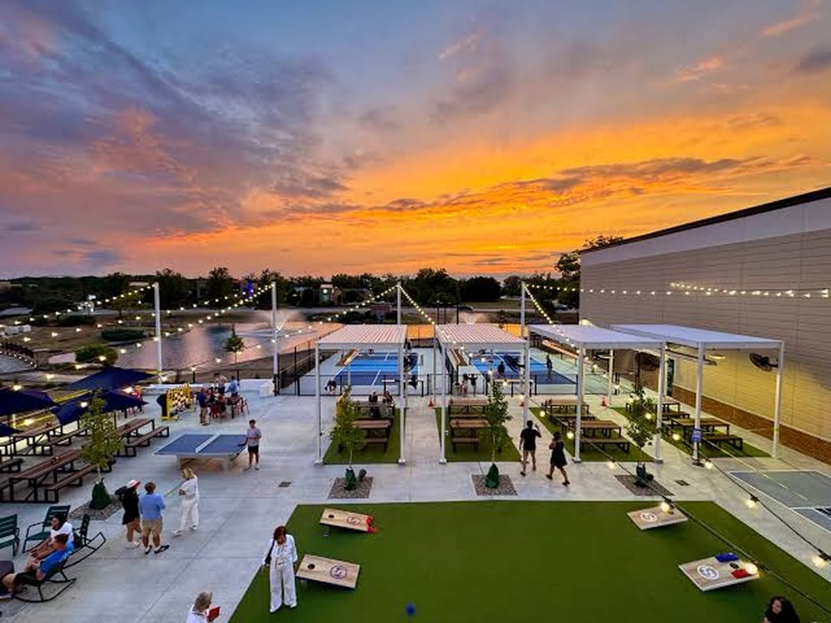 Smash Park Westerville outdoor pickleball courts cornhole and patio at sunset