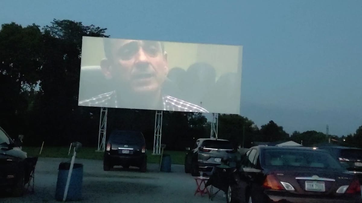 Cars facing the South Drive-In screen under twilight sky
