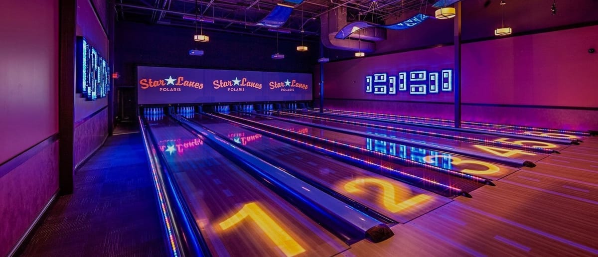 Bowling lanes with Star Lanes Polaris branding and cosmic neon lighting